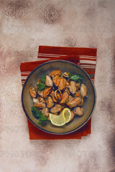 Mussels no shell, boiled, mussels, peeled, in a bowl, with lemon and parsley, Chilean mussels, top view, no people