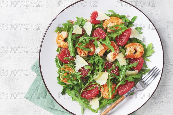 Fresh shrimp salad with arugula, grapefruit, and parmesan served in a bowl
