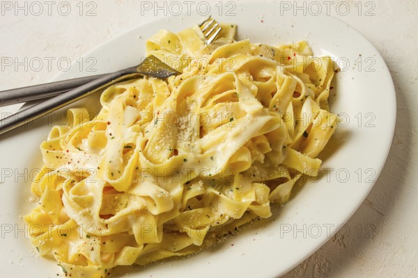 Fettuccine, tagliatelle, in creamy garlic sauce, Italian traditional cuisine, pasta carbonaro