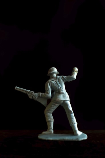 A soldier figurine stands confidently in a dynamic pose, holding a rifle pointed forward
