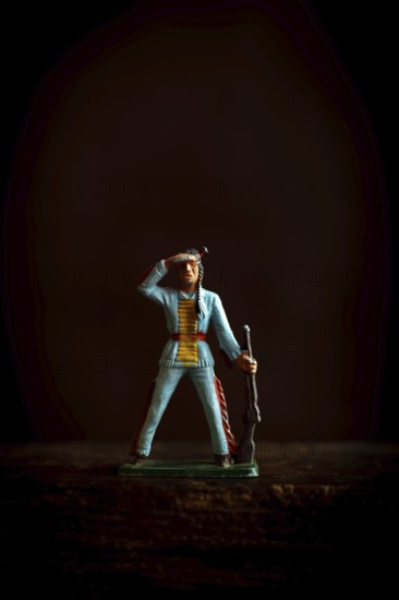 Intricate Native American Indian figure toy figurine in a blue uniform confidently salutes while holding a rifle