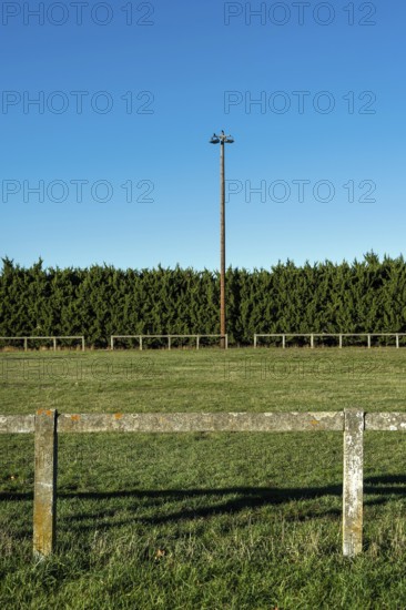 Rural football field surrounded by greenery and bright blue sky on a sunny day. Puy de Dome, Auvergne, France
