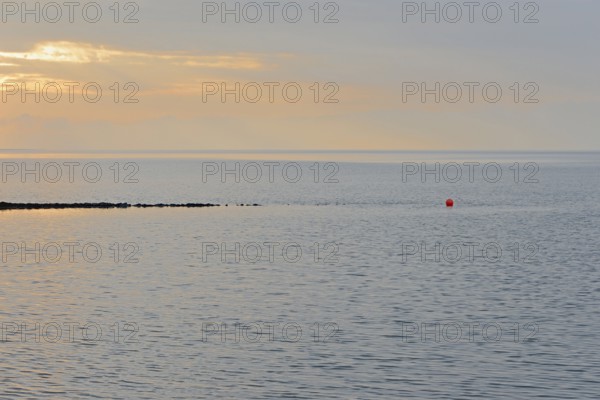 Evening mood at the Wadden Sea, stone groyne with red buoy, North Sea, Norddeich, Lower Saxony, Germany