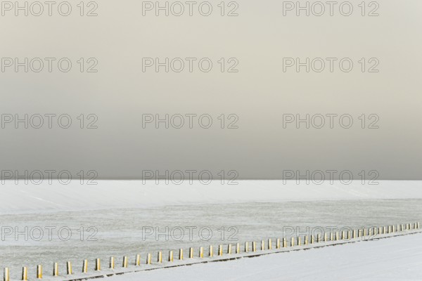 Winter day, onset of winter, snow-covered dyke and boundary piles, North Sea, Norddeich, Lower Saxony, Germany