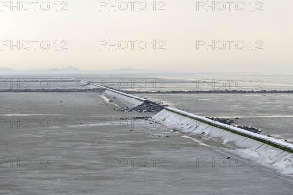 North Sea coast, cloudy winter day, Wadden Sea at low tide, stone groynes as coastal protection, North Sea, Norddeich, Lower Saxony, Germany