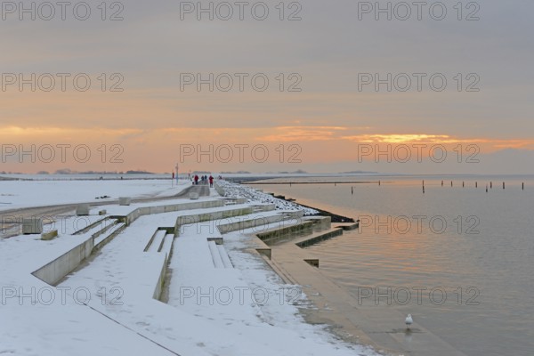 Evening atmosphere on the snow-covered beach promenade of Norddeich, North Sea, Lower Saxony, Germany