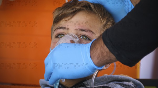 A doctor examines children's malnutrition inside a refugee camp