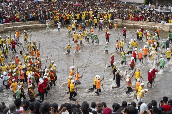 People from the Pnar community march in a circle as they celebrate an event organized to mark the Behdienkhlam festival in Jowai, India on July 14, 2025. Behdienkhlam is a vibrant annual festival celebrated by the Pnar (Jaintia) community of Meghalaya, especially in Jowai, to drive away plague and diseases and to pray for a good harvest. Observed in July after the sowing season, it features traditional rituals, offerings to ancestral spirits, and the grand procession of beautifully decorated bamboo structures called rots, which are later immersed in a sacred muddy pool known as Ka Aitnar
