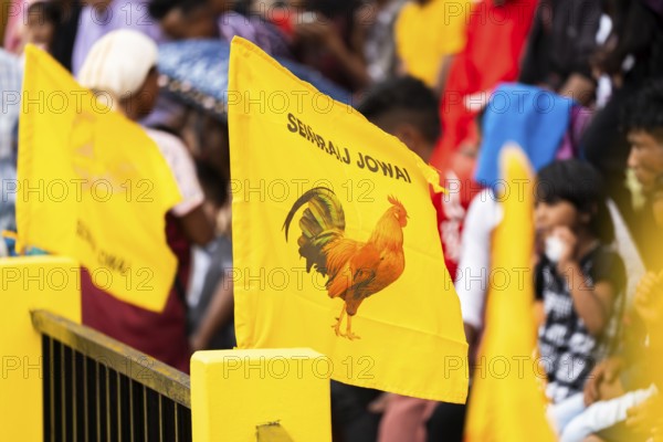 JOWAI, INDIA - JULY 14: A flag featuring a hen during celebrate an event organised to mark the Behdienkhlam festival in Jowai, India on July 14, 2025. Behdienkhlam is a vibrant annual festival celebrated by the Pnar (Jaintia) community of Meghalaya, especially in Jowai, to drive away plague and diseases and to pray for a good harvest. Observed in July after the sowing season, it features traditional rituals, offerings to ancestral spirits, and the grand procession of beautifully decorated bamboo structures called rots, which are later immersed in a sacred muddy pool known as Ka Aitnar