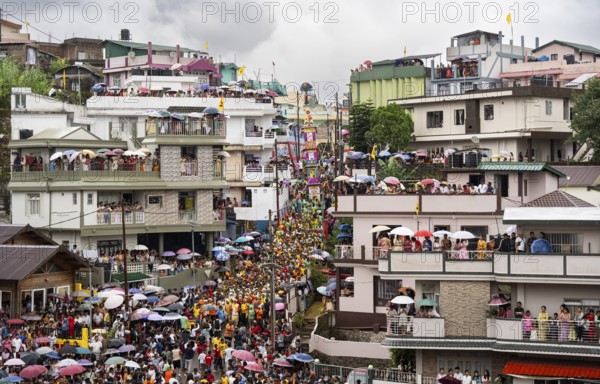 People from the Pnar community emjoy the Behdienkhlam festival from rooftop in Jowai, India on July 14, 2025. Behdienkhlam is a vibrant annual festival celebrated by the Pnar (Jaintia) community of Meghalaya, especially in Jowai, to drive away plague and diseases and to pray for a good harvest. Observed in July after the sowing season, it features traditional rituals, offerings to ancestral spirits, and the grand procession of beautifully decorated bamboo structures called rots, which are later immersed in a sacred muddy pool known as Ka Aitnar