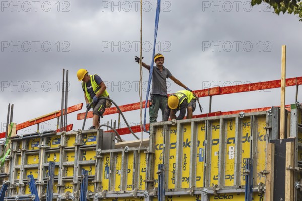 Construction worker concreting a wall. Construction site for an apartment block in Stuttgart, Baden-Württemberg, Germany
