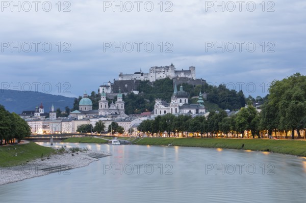 The city of Salzburg with the fortress on the Salzach shines in the first light of summer morning