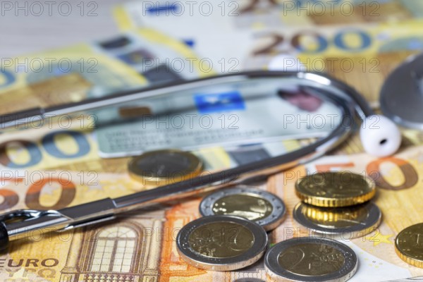 Health insurance contributions Symbolic image: health card, stethoscope and cash