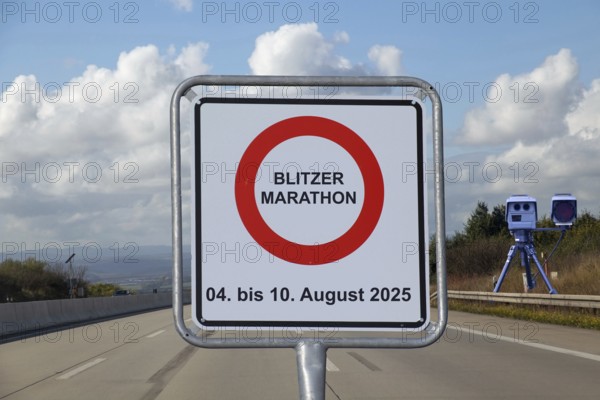 (Photomontage) Speed camera marathon Symbolic image: sign with the words BLITZERMARATHON 04 TO 10 AUGUST 2025 in front of a motorway, with a mobile speed trap at the side