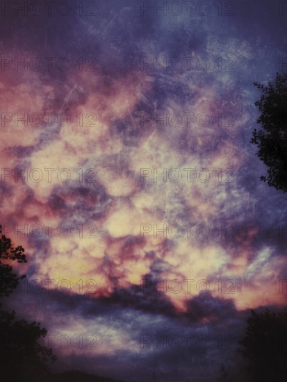 Colorful cotton candy clouds illuminate the twilight sky with vibrant hues of pink, purple, and orange as evening falls