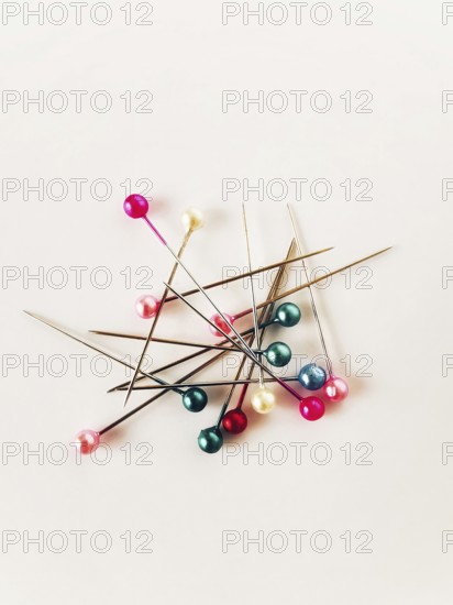 Various sewing pins with colorful heads are scattered across a light background, illustrating the vibrant tools of the crafting trade. This collection celebrates creativity and DIY projects