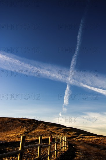 A rustic stretch of barbed wire fencing runs along a pathway in the Regional Nature Park of Volcans d'Auvergne, Puy de Dome, Auvergne Rhone Alpes, France