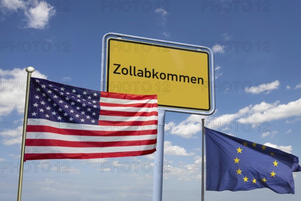 (Photomontage) Symbolic image of the customs agreement between the EU and the USA: town sign with the inscription ZOLLABKOMMEN with American and European flags against a blue sky