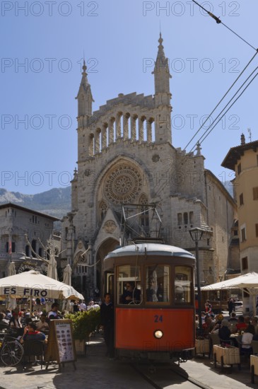 Historic tram Red Lightning in front of the church of Sant Bartomeu, Soller, Majorca, Balearic Islands, Spain