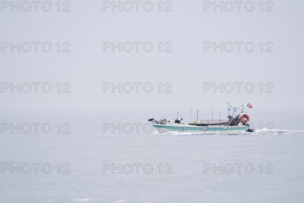 Fishing boat in the fog on the sea, Lagos, Algarve, Portugal