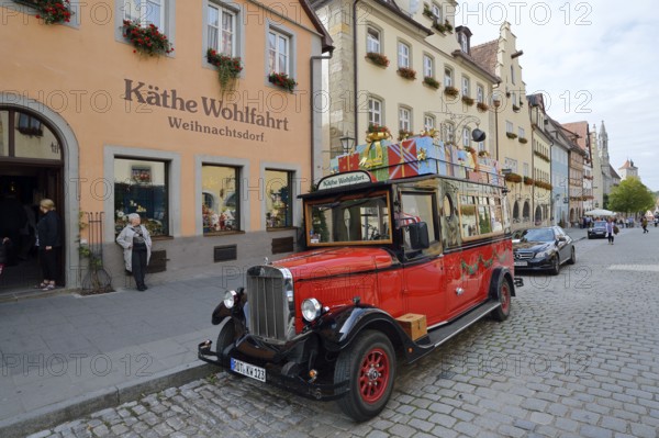 Käthe Wohlfahrt Christmas Village shop, in front of it a vintage car on the street, Rothenburg ob der Tauber, Middle Franconia, Bavaria, Germany