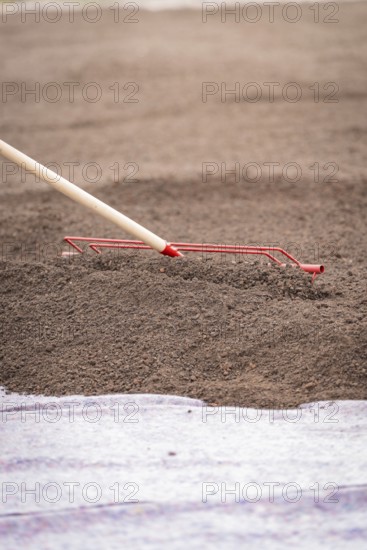 Close-up of a tool spreading soil on a construction site, roof greening, house construction, climate neutral