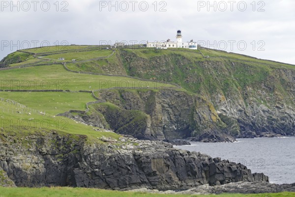 A lighthouse stands on high cliffs above a rough, cloudy coast, Sumburgh Head, Robert Louis Stevensen, Shetland Islands, Scotland, Great Britain
