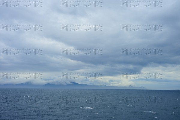 The wide sea under a cloudy sky with mountains in the distance, summer, Cook Strait, North Island, South Island, New Zealand