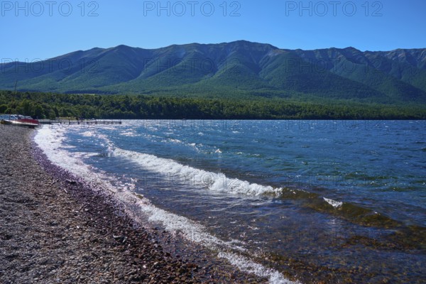 Beach with pebbles, waves crashing on the shore, peaceful mountain landscape, summer, Lake Rotoiti, Saint Arnaud, Tasman Region, South Island, New Zealand