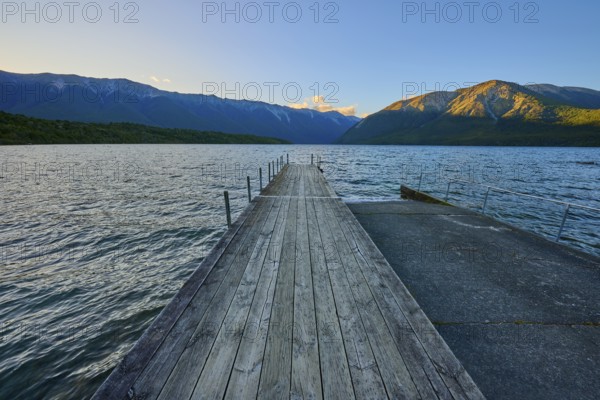 Wooden jetty at the lake with mountain landscape at dusk, summer, Lake Rotoiti, Saint Arnaud, Tasman Region, South Island, New Zealand