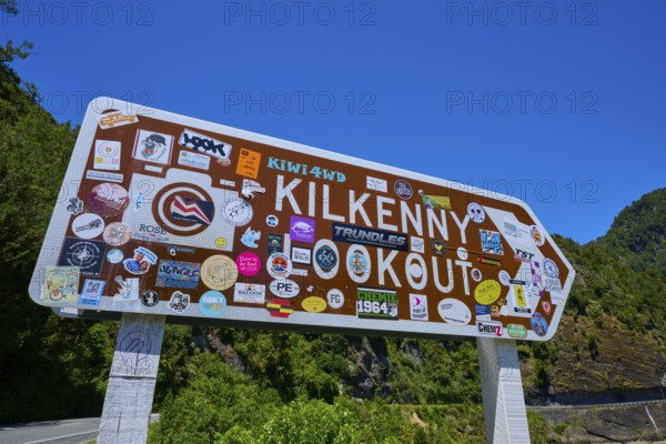 Sign at tourist lookout with various colourful stickers, Kilkenny Lookout, Lower Buller Gorge, Buller River, South Island, New Zealand