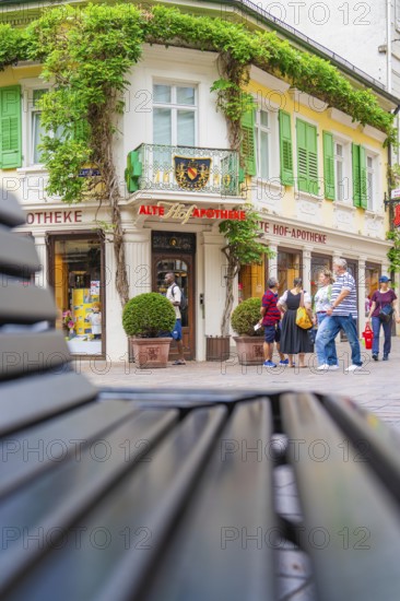 Exterior view of a historic pharmacy, surrounded by plants and people, Baden Baden, Germany