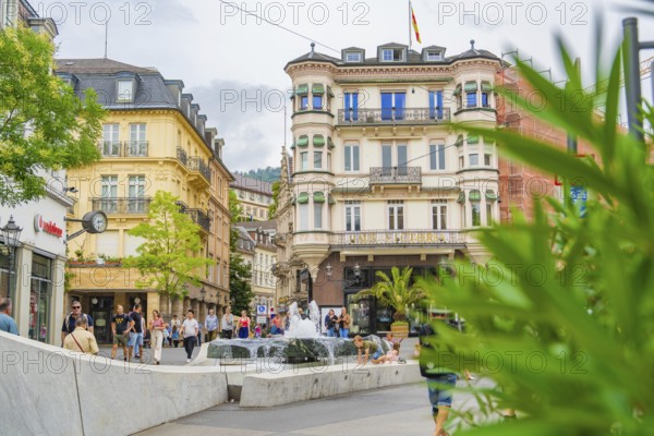 Town square with a fountain and historic buildings, bustling with people, Baden Baden, Germany