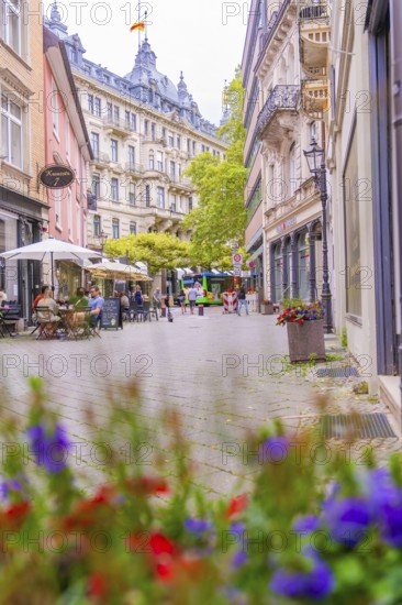 Lively street with cafés and flowers in the foreground, framed by historic buildings, Baden Baden, Germany