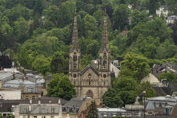 Gothic church with high towers embedded in a wooded urban landscape, Baden Baden, Germany
