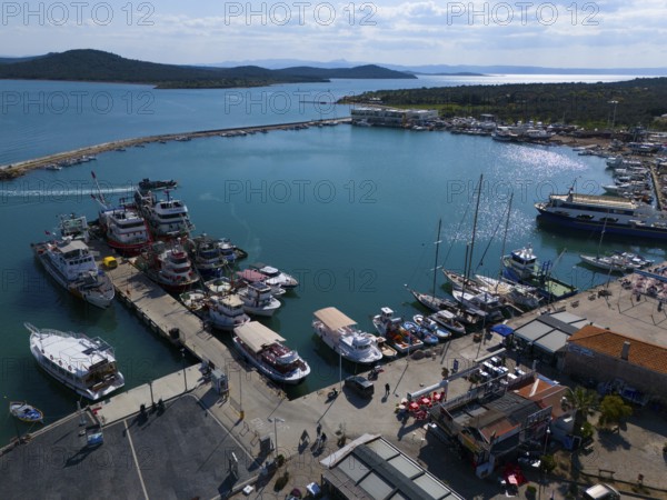 Sunny harbour with boats and yachts, surrounded by azure blue water and landscape, aerial view, Alibey, Alibey Adasi Island, Ayvalik, Turkey