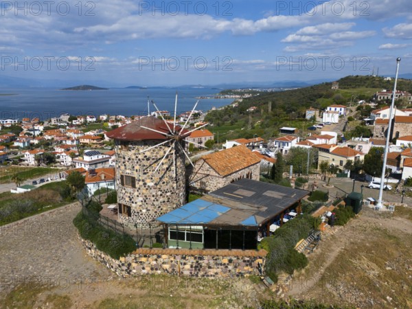 Coastal panorama with striking windmill, surrounded by houses and hills, aerial view, Alibey, Alibey Adasi Island, Ayvalik, Turkey