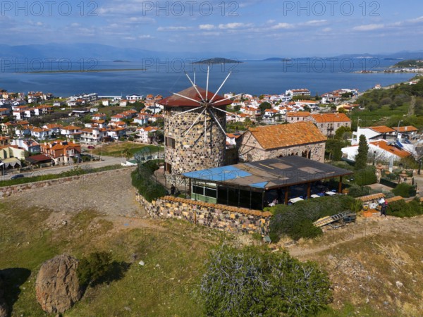 Historic windmill with sea view, surrounded by houses and green landscape, aerial view, Alibey, Alibey Adasi Island, Ayvalik, Turkey