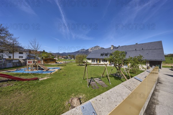 Catholic kindergarten St.Bruder Klaus, building, playground equipment, swing, sandpit, meadows, mountain landscape, mountains, blue sky, cirrostratus clouds, Bayerisch Gmain, district Berchtesgadener Land, Bavaria, Germany