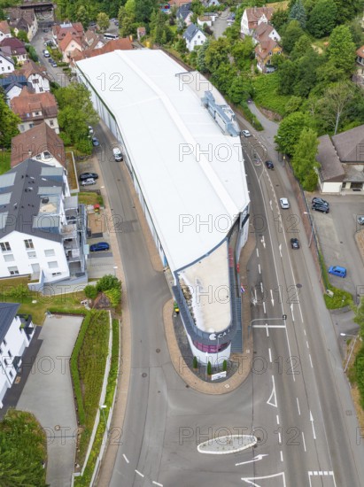 Aerial view of a modern building in an urban environment with green trees and houses, City Centre Calw, Germany