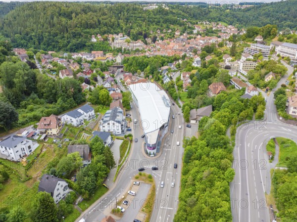 Aerial view of a modern building in a green, urban environment with nearby wooded areas, City Centre Calw, Germany