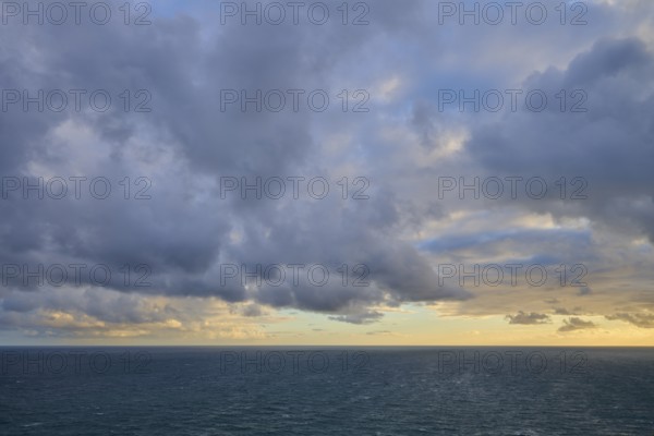 Cloudy sky over a calm, wide ocean at sunset, summer, Nugget Point Lighthouse, Ahuriri Flat, Otago, South Island, New Zealand