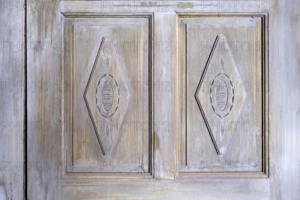 Antique wooden door with carved patterns and faded paintwork, Netherlands