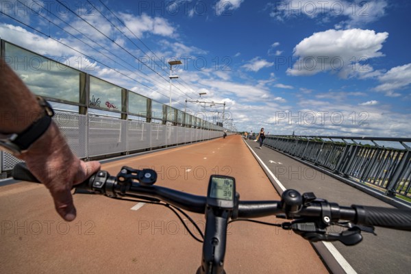 Ride over the Snelbinder Brug bicycle and pedestrian bridge, over the river Waal near Nijmegen, was built on the existing railway bridge, fast cycle path connection from the city centre of Nijmegen and the new housing estates in the Waalsprong district, Netherlands