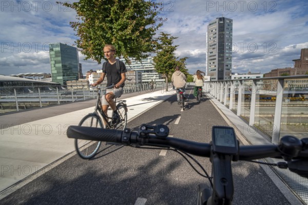 Cycling over the Moreelsebrug, pedestrian and cyclist bridge over the tracks of Utrecht Centraal, Central Station, Rabobank