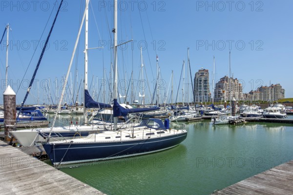 Sailing boats and recreational motorboats moored in marina of fishing village and seaside resort Breskens along Western Scheldt, Zeeland, Netherlands