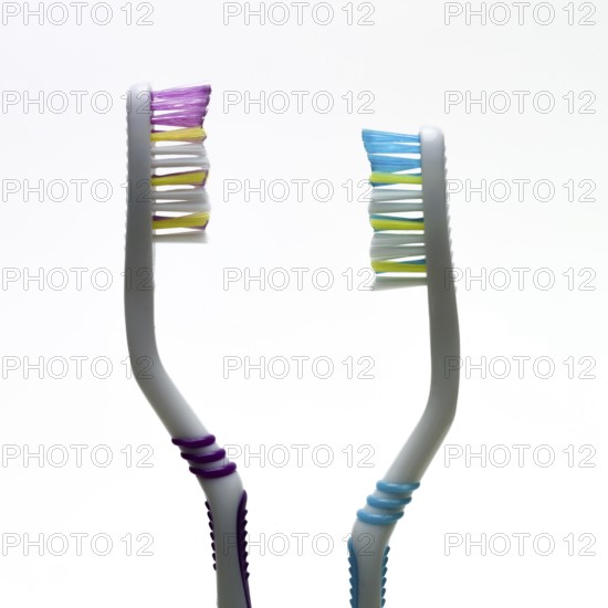 A pair of toothbrushes with bright bristles in pink and blue showcase effective hygiene tools. Their ergonomic design emphasizes comfort during daily brushing routines