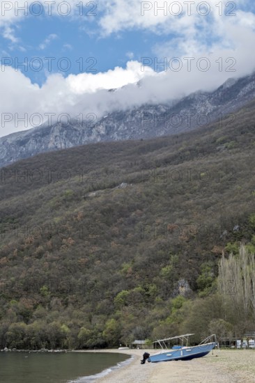 Boat on the shore of Lake Ohrid, snow-capped mountains in the background, North Macedonia