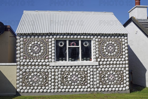 A small house with ornate shell decorations under a blue sky, Hammavoe, Shetland Islands, Scotland, United Kingdom