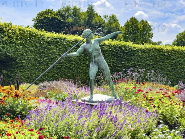 Sculpture Statue of bronze javelin thrower from 1937 by sculptor and artist Ernst Seger in flower roundabout Lindenrund in Grugapark Essen, Essen, North Rhine-Westphalia, Germany